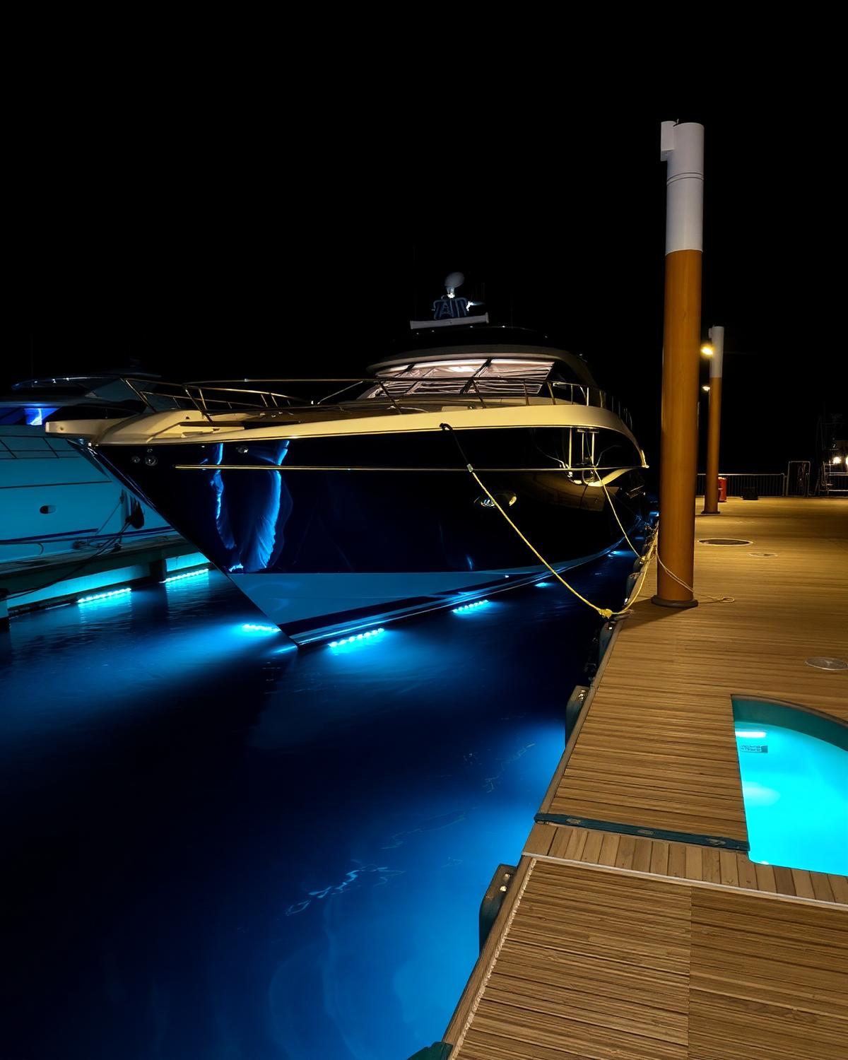 Yacht with underwater blue LED lighting at a private dock